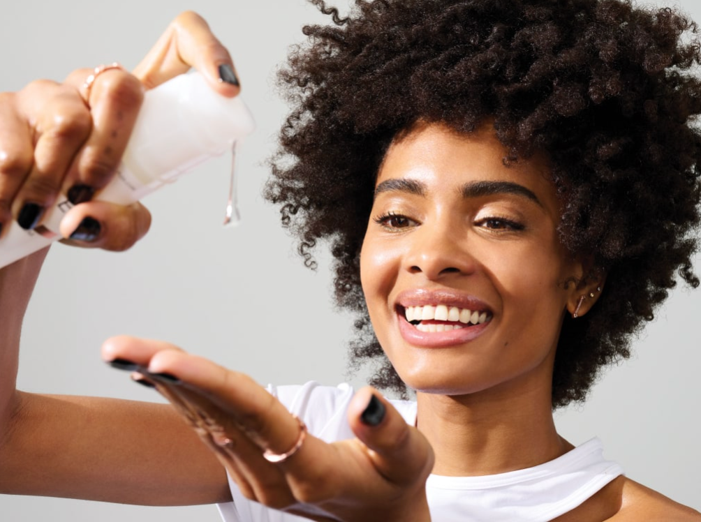 women squirting serum into palm of hand