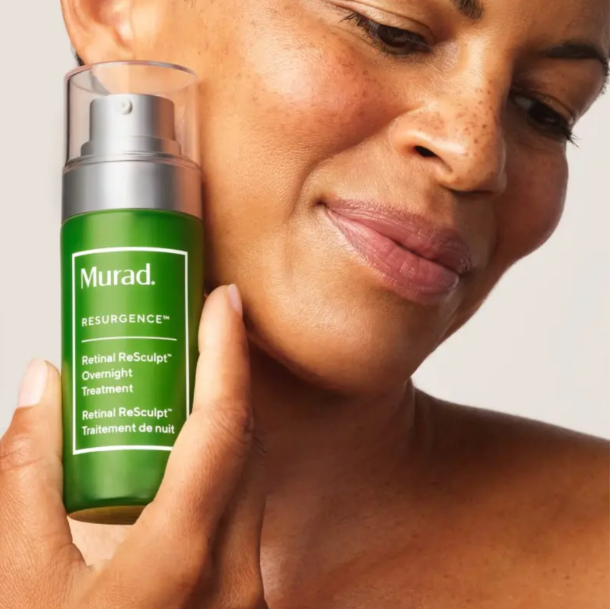 women holding murad overnight treatment next to face