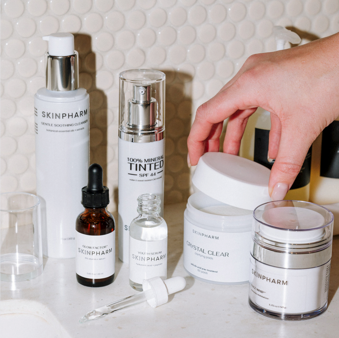 skincare product line with hand reaching for the products 